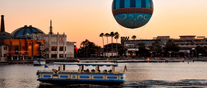 Panoramic view of Disney Springs and water taxi on colorful sunset background at Lake Buena Vista area in Orlando, Florida, USA.