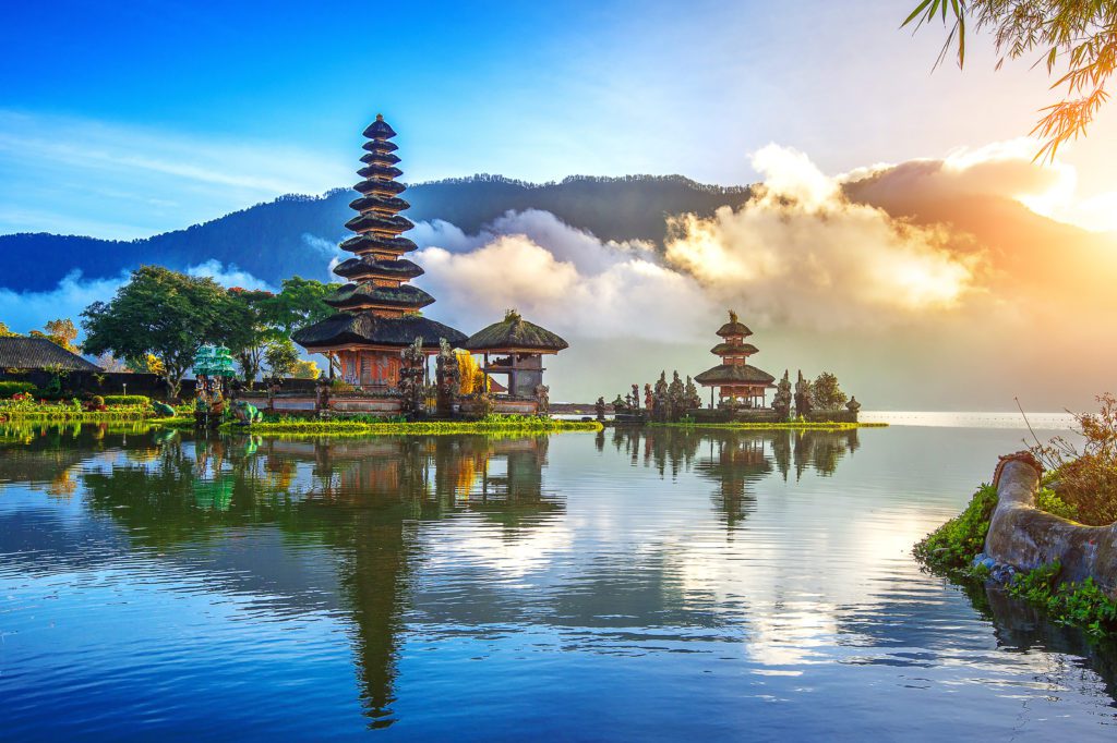 A temple in Indonesia overlooking a lake in front of a mountain.