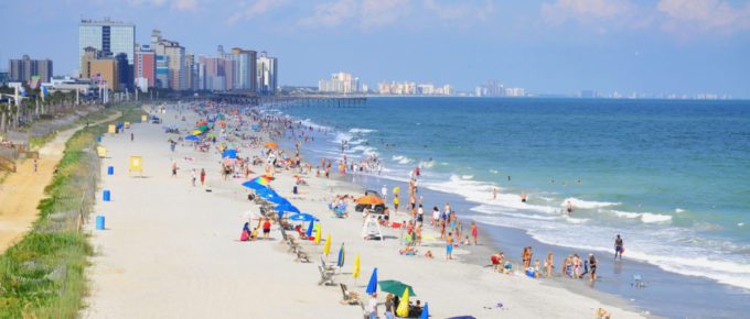 View of Myrtle Beach in South Carolina with a lot of people under colorful umbrellas.