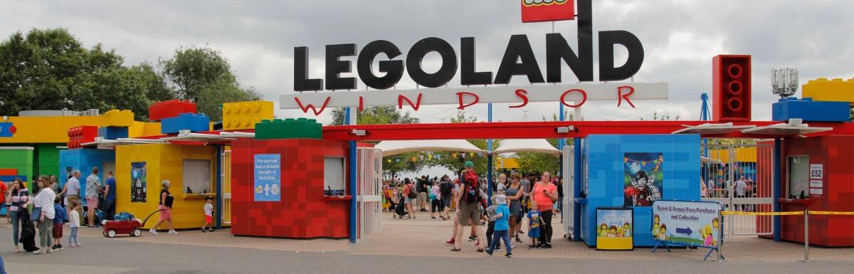 Entrance area of Legoland Windsor, UK with a lot of people around on a cloudy day.