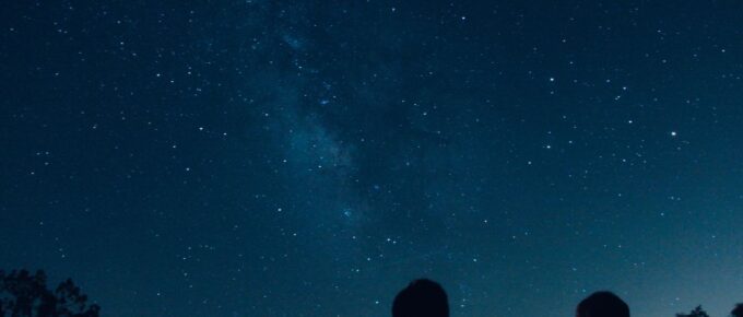 Silhouette of two people watching the stars at night.