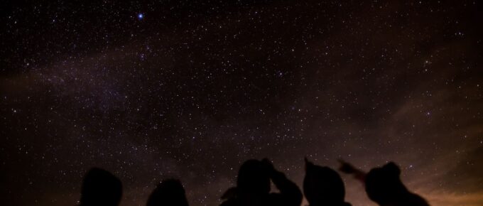 Silhouette of a group of friends stargazing.