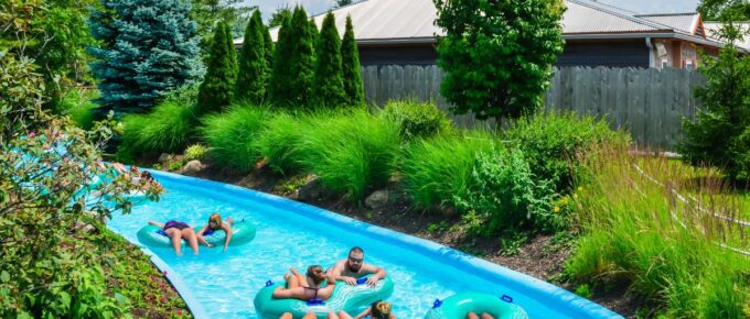 People floating on tubes along a lazy river ride during the day.